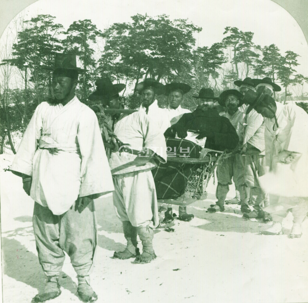 외국공사 전속 가마꾼 (1904년). 사진 속 인물이 선교사인지 외국공사인지는 정확하지 않으나 체격이 크다보니 그 무게에 끌채(가마채)가 휘어져 있는 것을 볼 수 있다. 대나무로 만들어진 의자는 발을 올려놓을 수 있도록 만들어졌다. 겨울의 추운 날씨를 보여주기라도 하듯 사진 속 인물은 무릎 담요를 덮고 있으며, 손에 여성용 핸드백이 들려 있는 것으로 보아 사진을 찍어준 사람은 아마도 그의 아내인 듯하다. 당시 사진은 외국인이 아니면 찍기 어려웠다. 뚜껑이 없고 의자 같이 생긴 가마를 ‘남여(籃輿)’라고 하는데 의자 모양의 몸체에 기다란 끌채(가마채)가 양 옆에 앞뒤로 길게 뻗은 것이 특징이다. ‘남여’는 본래 왕과 세자가 궁궐 밖이나 궁궐 안 가까운 거리를 갈 때 이용하거나 나이가 든 재상이나 대신도 타고 다녔다. 사진 속 가마와 흡사 ‘남여’와 비슷하게 생겼으나 재료나 그 용도에서는 차이가 있다. (제공: 정성길 기록사진연구가) ⓒ천지일보 2024.09.16.