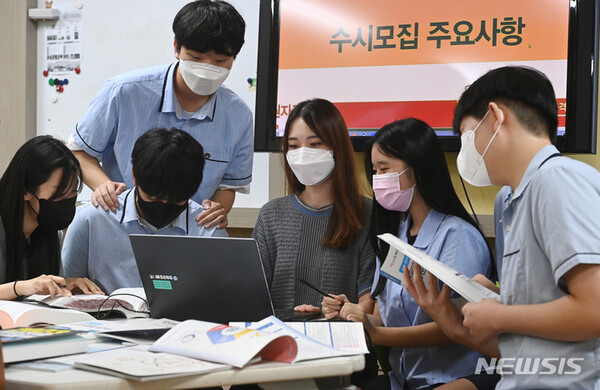 [수원=뉴시스] 경기도 수원시 조원고등학교에서 고3 학생들이 선생님과 진학자료집을 살펴보고 있다. 