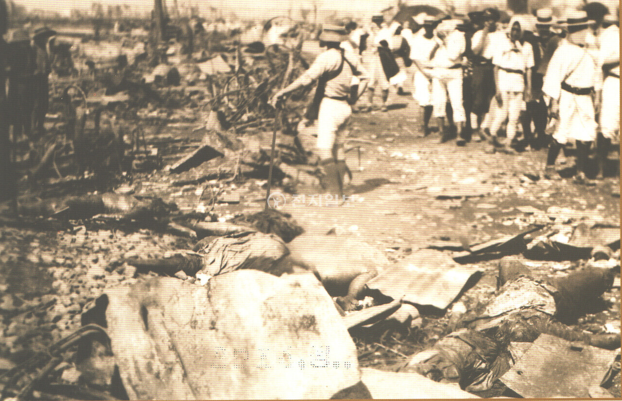 자경단 인간사냥(1923년). 민간에서 자경단을 조직해 조선인으로 확인되면 현장에서 살해했다. 이들은 죽창이나 몽둥이, 일본칼 등으로 무장해 만행을 자행했다. 중절모를 쓴 자경단이 조선인을 사냥하기 위해 쇠꼬챙이를 들고 주변을 살피고 있고 처참하게 살해된 시신들이 그냥 방치되고 있다. (제공: 정성길 기록사진연구가) ⓒ천지일보 2024.09.03.