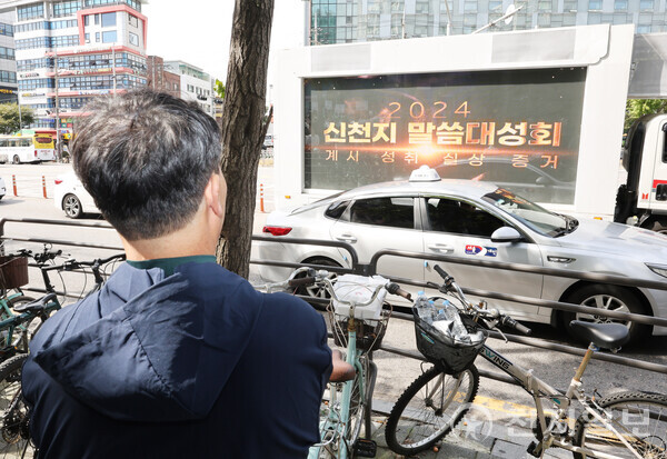[천지일보=남승우 기자] 5일 서울 영등포구 바돌로매지파 영등포교회에서 ‘2024 신천지 계시 성취 실상 증거 말씀대성회’가 열린 가운데 한 시민이 말씀대성회 홍보 차량을 바라보고 있다. 이날 목회자 400여명 등 총 1만 4000여명이 참석했다.ⓒ천지일보 2024.10.05.