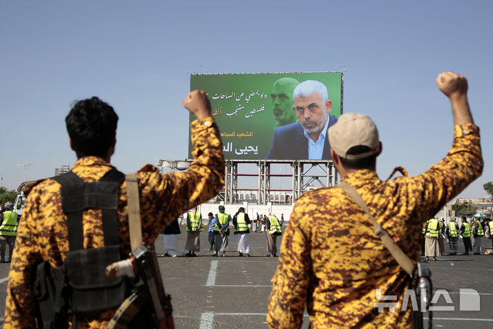 예멘 군인들이 18일(현지시간) 예멘 사나에서 열린 반 이스라엘 집회에 참석해 하마스 지도자 야히아 신와르가 나온 광고판 앞에서 구호를 외치고 있다. (출처: 뉴시스)