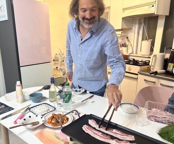 서울 스테이 집밥 쿠킹클래스에 참여한 외국관광객이 삼겹살을 굽고 있다.(제공=서울시)ⓒ천지일보 2024.11.27.