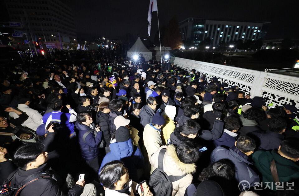 [천지일보=박준성 기자] 비상계엄령이 선포된 4일 서울 영등포구 국회의사당 정문 앞에서 시민들이 윤석열 대통령 퇴진 촉구 구호를 외치고 있다. ⓒ천지일보 2024.12.04.