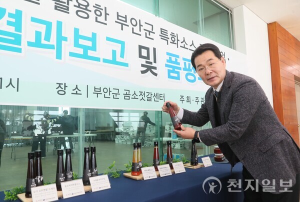 권익현 부안군수가 18일 곰소젓갈발효센터에서 열린 개발 보고회에 참석해 곰소젓갈 특화소스를 들어 보이고 있다. (제공: 부안군청) ⓒ천지일보 2024.12.18.