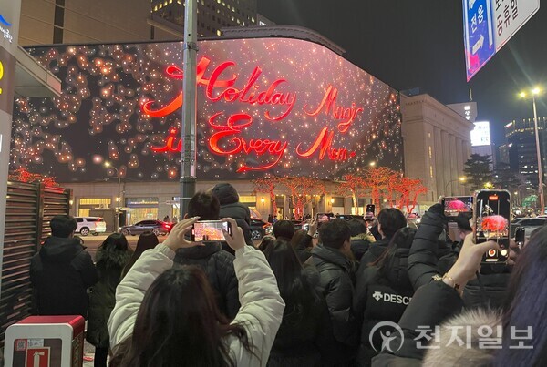 [천지일보=김민희 기자] 크리스마스이브인 24일 서울 중구 신세계 백화점 본점 앞에서 시민들이 건물 외벽에 설치된 미디어 파사드를 촬영하고 있다. ⓒ천지일보 2024.12.24.