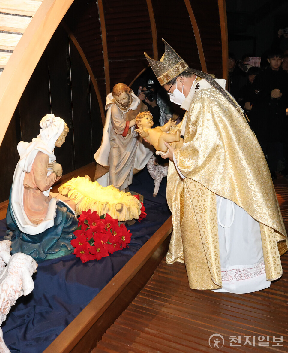 [천지일보=남승우 기자] 천주교 서울대교구장 정순택 대주교가 25일 새벽 서울 중구 명동성당 앞마당에서 아기 예수를 말구유에 안치하는 구유 예절의식을 하고 있다. ⓒ천지일보 2024.12.25.
