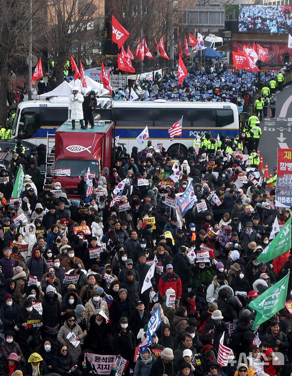 [서울=뉴시스] 크리스마스 휴일인 25일 오후 서울 용산구 대통령 관저 인근에서 보수단체와 진보당이 경찰버스를 사이에 두고 각각 윤석열 대통령 수호 집회와 규탄 집회를 하고 있다. 2024.12.25.