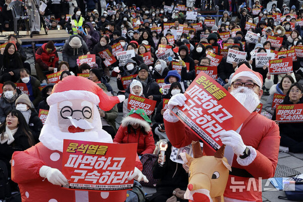 [서울=뉴시스] 25일 서울 종로구 송헌공원 인근에서 촛불행동 주최로 열린 촛불문화제에서 참석자들이 윤석열 대통령 파면 국민의힘 해산을 촉구하고 있다. 2024.12.25.