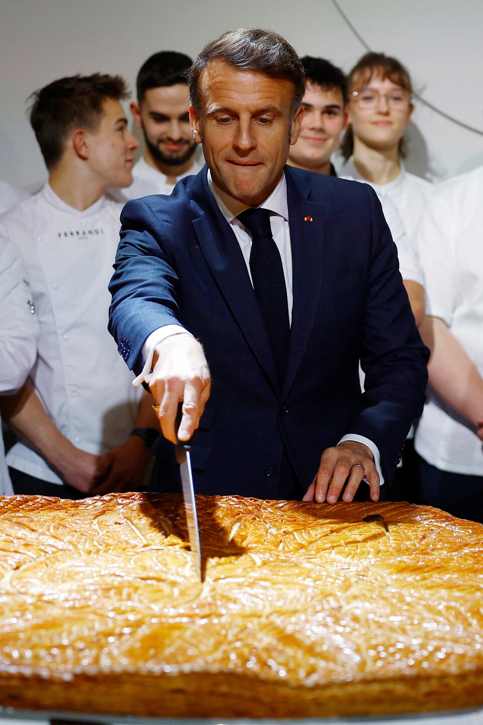 에마뉘엘 마크롱 프랑스 대통령이 6일 프랑스 파리 엘리제궁에서 열린 전통 주현절 케이크 행사에서 프랑스 제빵 및 제과 연맹 회원들에게 연설한 후 케이크를 자르고 있다. (출처: 연합뉴스)