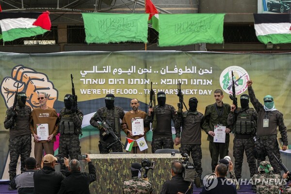 8일(현지시간) 가자지구 중부 데이르알발라에서 하마스 무장대원들이 석방 대상인 이스라엘 인질 3명을 무대에 세웠다. 2025.2.8 (출처: AP, 연합뉴스)