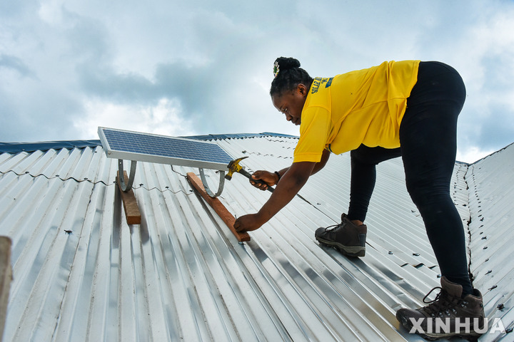 2022년 5월 24일 카메룬 티코의 한 주택 지붕에 태양광 패널을 설치하는 에포시 은조 모넹기. (출처: 뉴시스)