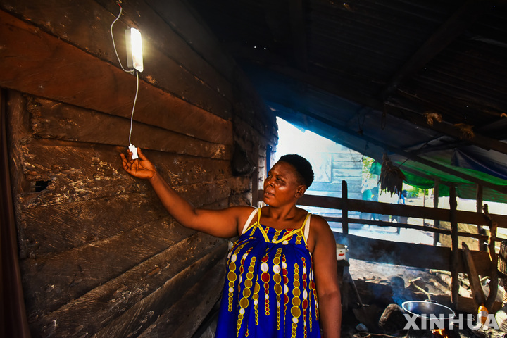 이날 티코에서 한 여성이 태양열 전구를 켜고 있는 모습. (출처: 뉴시스)