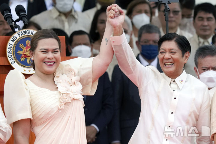 Philippine President Ferdinand Marcos Jr., center right, and Vice President Sara Duterte, daughter of former Philippine President Rodrigo Duterte, raise hands during the inauguration ceremony at National Museum on Thursday, June 30, 2022 in Manila, Philippines. (AP Photo/Aaron Favila, File, 뉴시스)