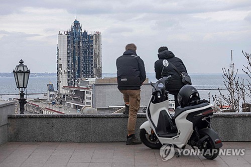 미국 백악관은 25일(현지시간) 우크라이나 전쟁 휴전을 위한 실무 협상 결과를 소개한 보도자료에서 “러시아와 우크라이나가 30일간 흑해 해상 공격과 에너지 목표물에 대한 공격을 중단하기로 합의했다”면서 “러시아에 대한 일부 제재를 해제하기 위해 노력하기로 합의했다”고 밝혔다. 사진은 흑해 항구도시 오데사에서 파괴된 오데사 호텔 바라보고 서 있는 두 남성 (출처: AFP 통신, 연합뉴스)