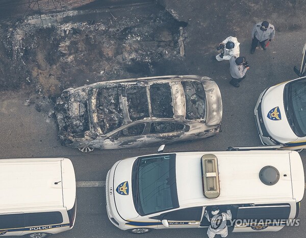 26일 경북 영덕군 영덕읍 한 도로에서 발견된 산불에 불탄 차량을 경찰이 조사하고 있다. (출처: 연합뉴스)
