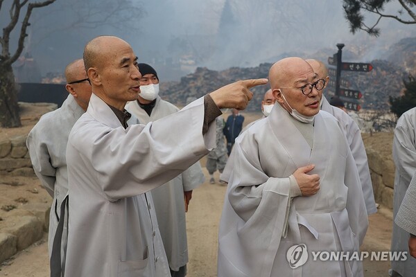 대한불교조계종 총무원장 진우스님(오른쪽)이 26일 산불 피해를 본 경북 의성군 고운사를 방문해 고운사 주지 등운스님(왼쪽)으로부터 산불 피해 상황을 듣고 있다. 국가 지정 문화유산 보물로 지정된 고운사 가운루와 연수전은 전날 덮친 산불에 타 전소됐다. (출처:연합뉴스)