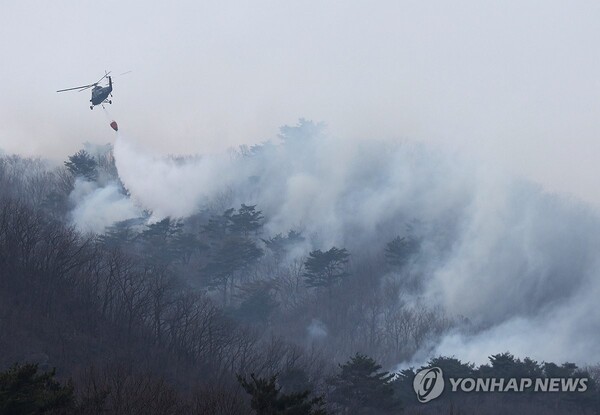 (울산=연합뉴스) 울산시 울주군 온양읍 산불 사흘째인 24일 진화 작업에 동원된 헬기가 물을 뿌리고 있다.