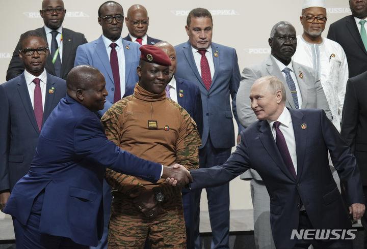 블라디미르 푸틴 러시아 대통령(오른쪽)과 필리프 뉴시 모잠비크 대통령이 2023년 7월 28일 러시아 상트페테르부르크에서 열린 러시아 아프리카 정상회의에서 단체 사진 촬영 중에 악수를 나누고 있다. 푸틴 대통령은 당시 회의에서 아프리카 국가들에게 많은 원조를 약속했다. (출처: 뉴시스)