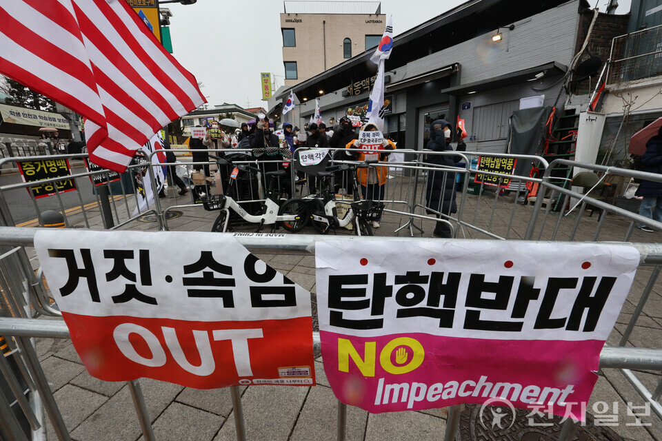 [천지일보=남승우 기자] 헌법재판소가 윤석열 대통령 탄핵심판 선고를 앞두고 논의를 이어가고 있는 30일 서울 종로구 헌법재판소 주변에 설치된 경찰 펜스에 탄핵 반대 촉구 피켓이 붙어 있다. ⓒ천지일보 2025.03.30.