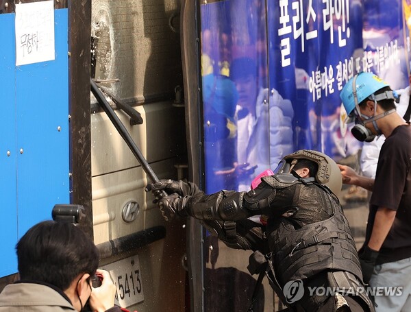 4일 서울 종로구 헌법재판소 인근에서 윤석열 대통령 지지 집회 참가자 중 한 명이 헌재의 윤 대통령 파면 결정에 경찰이 세운 가벽 사이로 보이는 차량을 부수고 있다. (출처: 연합뉴스)
