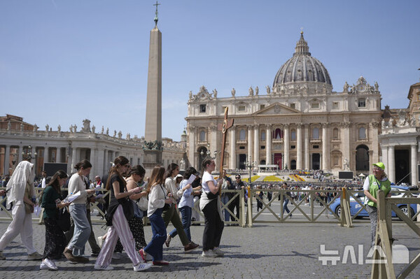 [바티칸시국=AP/뉴시스] 프란치스코 교황이 선종한 21일 바티칸의 성 베드로 광장에서 신자들이 십자가를 들고 이동하고 있다. 2025.04.21.