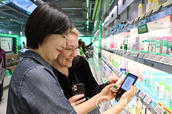 올리브영 명동 타운 직원이 전국 매장에 도입된 휴대용 번역기를 활용해 외국인 고객을 응대하고 있는 모습. (제공: CJ그룹) ⓒ천지일보 2025.04.30.