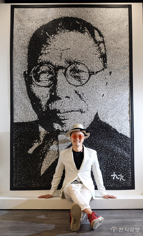 백범 김구 선생을 깊이 존경하는 구구킴 작가가 뱀범 선생을 핑거스탬핑으로 그린 자신의 작품 앞에서 환하게 웃고 있다. (사진 제공: 구구문화진흥원) ⓒ천지일보 2025.05.20.