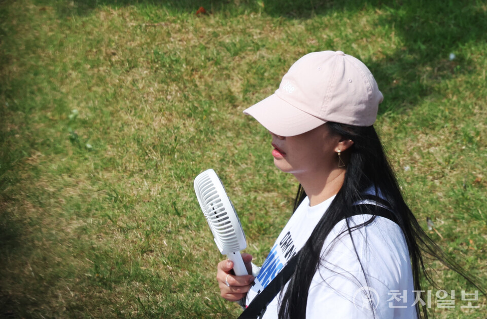 [천지일보=남승우 기자] 한낮 기온이 30도 가까이 오르며 무더운 날씨가 이어진 8일 서울 마포구 경의선숲길에서 시민이 손선풍기를 들고 이동하고 있다. ⓒ천지일보 2025.06.08.