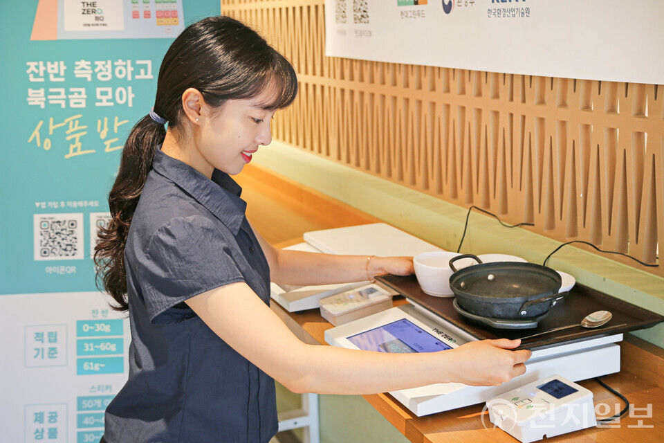 현대그린푸드가 운영 중인 단체급식 사업자에서 식사를 마친 고객사 임직원이 탄소중립포인트 제도 ‘잔반제로’ 항목 참여를 위해 식판 무게를 재고 있다. (제공: 현대그린푸드) ⓒ천지일보 2025.07.18.