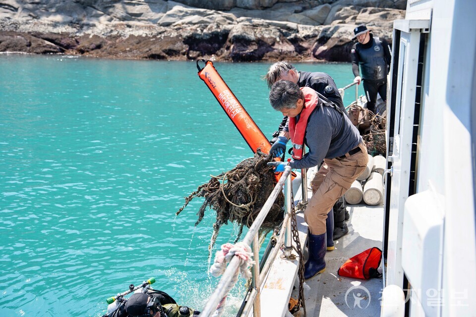 17일 전라남도 여수시 돌산 진목방파제 연안에서 수중 정화 작업을 진행하는 모습. 전문 스쿠버가 바다 속에서 수거한 폐그물을 끌어 올리고 있다. (제공: 롯데마트) ⓒ천지일보 2025.07.19.