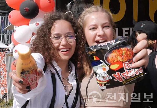 미국에서 열린 한류 행사장에서 현지 소비자들이 삼양식품의 불닭볶음면과 소스를 들고 기념촬영하고 있다. 삼양식품은 미국 수출의존도가 높지만 현지 생산기반이 없어 관세 직격탄을 맞고 있다. (제공: 삼양식품)