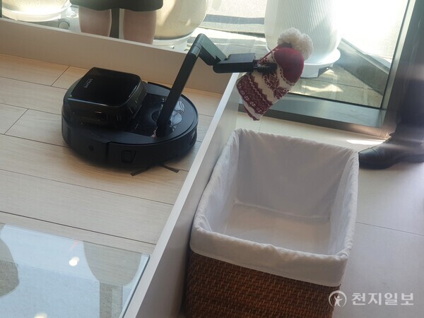 [천지일보=황해연 기자] 11일 서울 용산구 한남동에 오픈한 드리미 플래그십 스토어에서 로봇청소기 콘셉트 제품인 ‘사이버10’ 시연 모습. 내부에서 나온 두 기계식 팔을 이용해 바닥에 놓인 양말을 들어 올려 앞에 빈 통에 넣는 모습. ⓒ천지일보 2025.04.11.