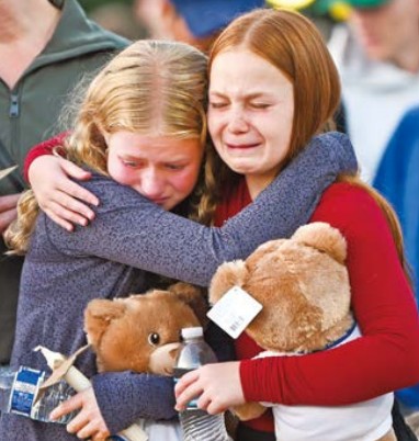 8월 27일(현지시간) 미국 미네소타주 미니애폴리스의 가톨릭 스쿨에서 총격 사건이 발생했다. 사진은 이 지역 공원 촛불 집회에서 서로를 위로하는 두 아이. (출처:EPA/연합)