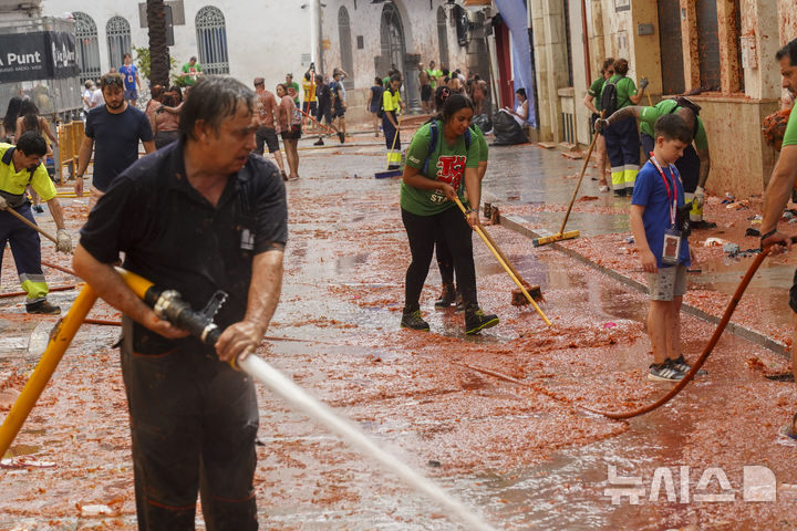 작년 8월 28일 축제가 끝난 후 거리를 청소하는 참가자들. (AP Photo/Alberto Saiz, 뉴시스)
