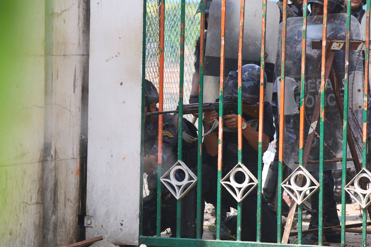 이날 카트만두 국회의사당 건물 밖에서 한 경찰관이 시위대를 향해 무기를 겨누고 있다. (AP Photo/Niranjan Shrestha, 연합뉴스)