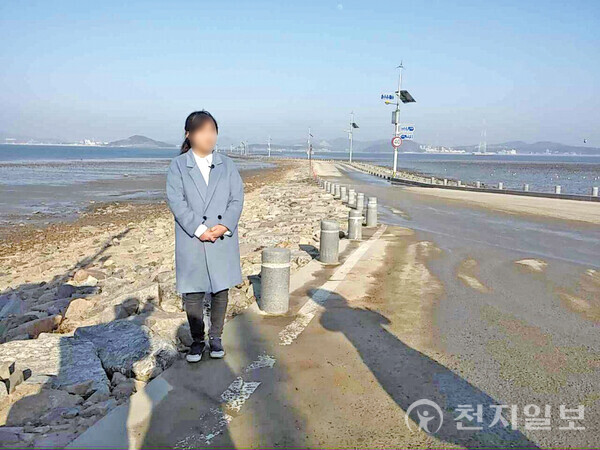 장은영(가명, 20대)씨가 처음 납치·감금됐던 제부도 펜션 앞 바다에 서 있다. 장씨 뒤로 보이는 도로는 썰물 때만 길이 열려 오갈 수 있다. ⓒ천지일보DB