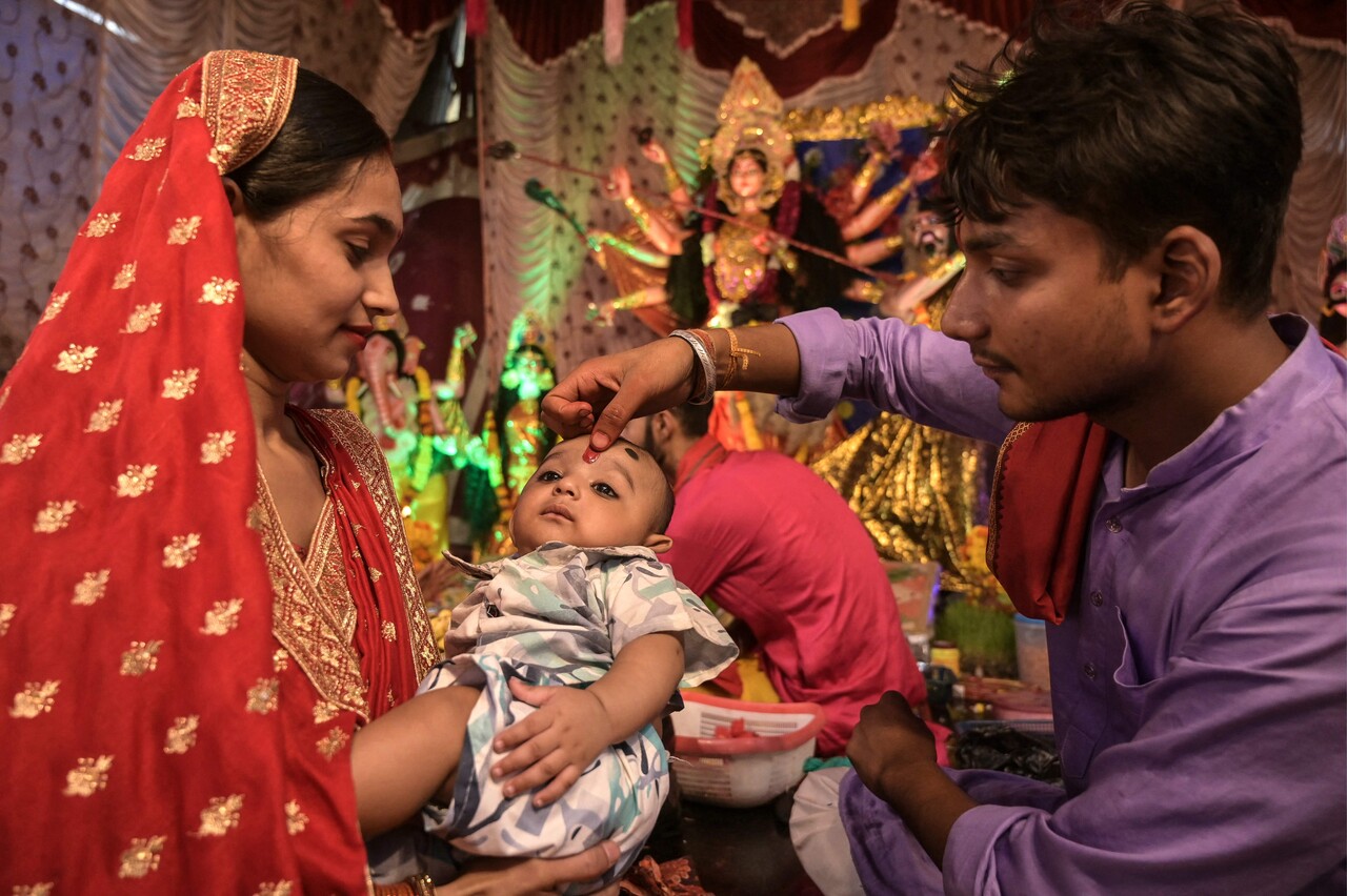 29일(현지시간) 암리차르에서 열린 두르가 푸자 축제 기간 한 사제가 힌두 여신 두르가의 신상 앞에서 한 아이의 이마에 ‘틸락(tilak, 성스러운 표식)’을 그려주고 있다. (Photo by Narinder NANU / AFP, 연합뉴스)