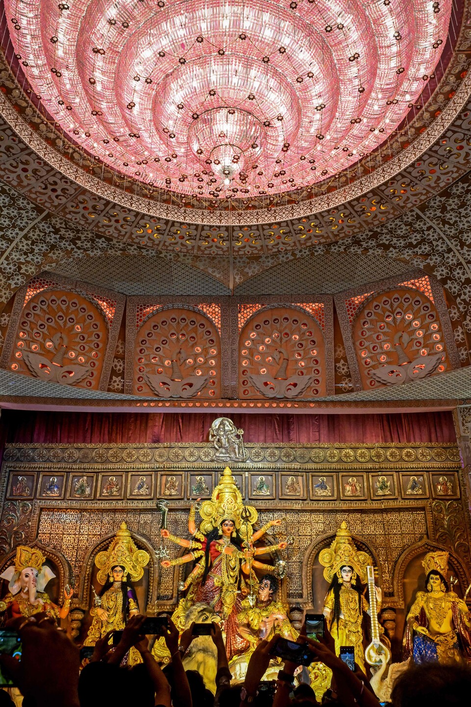 27일 콜카타에서 ‘두르가 푸자’ 축제를 앞두고 신도들이 힌두 여신 두르가의 신상이 모셔진 ‘판달’(임시 사원)을 방문하며 사진을 찍고 있다. (Photo by Dibyangshu SARKAR / AFP, 연합뉴스)