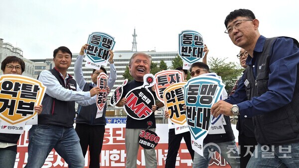[천지일보=배다솜 수습기자] 전국민주노동조합총연맹(민주노총)이 30일 서울 용산 대통령실 앞에서 ‘대미 투자 전면 중단 구금 노동자에 대한 사과 촉구’ 기자회견을 열고 트럼프 미국 대통령을 향해 방패를 들고 맞서는 상징 의식을 진행하고 있다. ⓒ천지일보 2025.09.30.