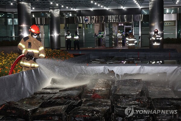 27일 밤 대전 유성구 국가정보자원관리원 화재 현장에서 소화수조에 담긴 불에 탄 리튬이온 배터리에 소방대원이 물을 뿌리고 있다. 2025.9.27 (출처: 연합뉴스)