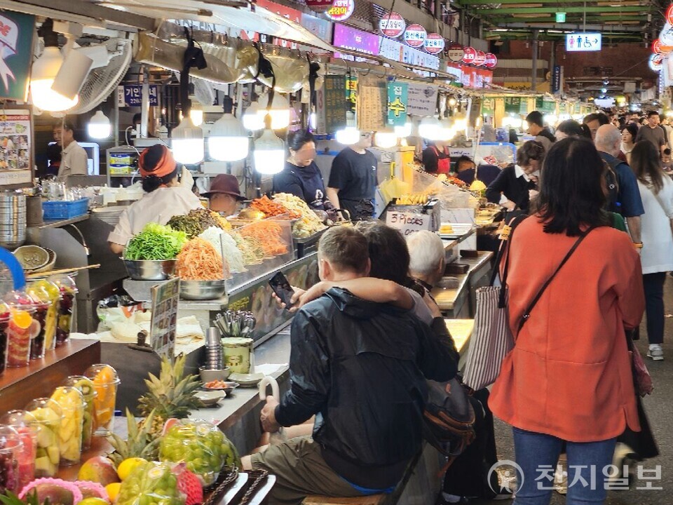 [천지일보=양효선 기자] 추석 전날인 5일 오후 서울 종로구 광장시장에서 먹자골목 벤치를 가득 메운 시민들과 관광객들이 전통 음식을 즐기고 있다. ⓒ천지일보 2025.10.05.