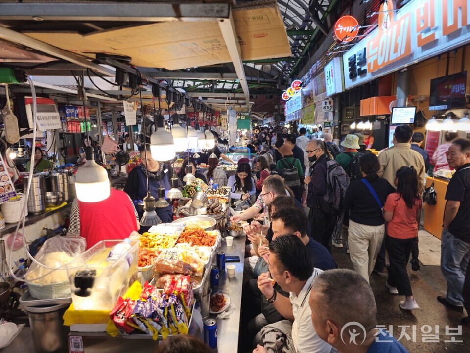 [천지일보=양효선 기자] 추석 전날인 5일 오후 서울 종로구 광장시장에서 빈대떡, 생과일주스 등 다양한 길거리 음식을 찾는 시민과 관광객들로 시장 통로가 인산인해를 이뤘다. 비가 내리는 날씨에도 시장을 찾은 발걸음이 끊이지 않으며 명절 특수를 실감케 했다. ⓒ천지일보 2025.10.05.