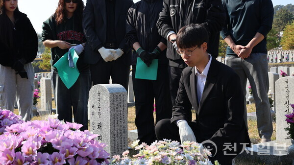 [천지일보=배다솜 기자] 5일 오전 서울 동작구 국립서울현충원에서 청년보수단체 봉사자들이 묘역관리 봉사에 앞서 육군 중장 고(故) 채명신 장군의 묘 앞에서 헌신의 뜻을 되새기며 묘비글을 읽고 있다. ⓒ천지일보 2025.11.05.