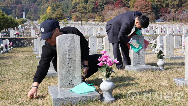 [천지일보=배다솜 기자] 5일 오전 서울 동작구 국립서울현충원 제2묘판에서 청년보수단체 봉사자들이 묘비 닦기, 잡초 제거 등 묘역관리 봉사활동을 하고 있다. ⓒ천지일보 2025.11.05.