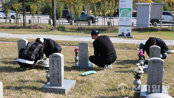 [천지일보=배다솜 기자] 5일 오전 서울 동작구 국립서울현충원 제2묘판에서 청년보수단체 봉사자들이 묘비 닦기, 잡초 제거 등 묘역관리 봉사활동을 하고 있다. ⓒ천지일보 2025.11.05.