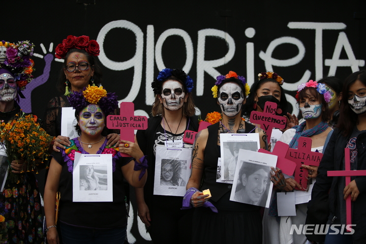 카트리나 복장을 한 여성들이 2022년 10월 30일 멕시코시티에서 죽은 자의 날 기념의 일환으로 여성 살인 피해자들을 위한 정의를 요구하는 시위가 시작되기 전에 단체 사진을 찍고 있다. (출처: 뉴시스)