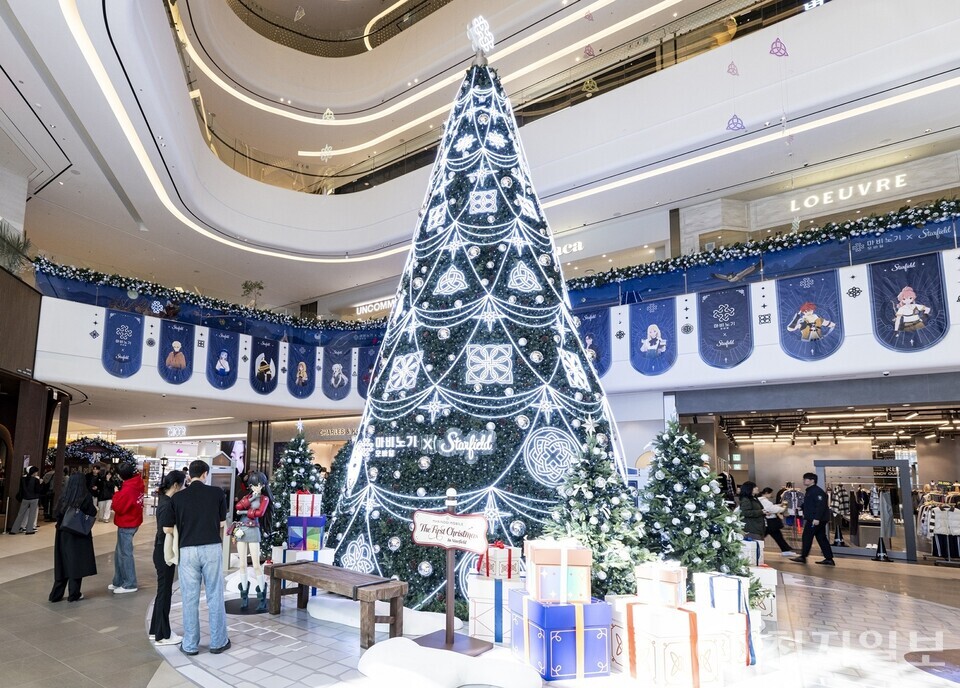 스타필드 안성 중앙 아트리움에 설치된 ‘마법노트×스타필드’ 초대형 메인 트리. 푸른빛 일루미네이션과 캐릭터 장식이 어우러져 환상적인 겨울 무드를 연출하며 방문객들의 포토 스폿으로 주목받고 있다. (제공: 신세계프라퍼티)