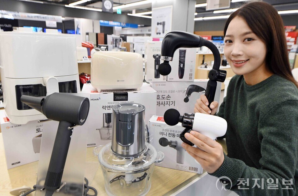 홈플러스가 ‘반값가전’ 라인업을 강화하며 판매 성과를 확대하고 있다. 모델이 매장에서 ‘인썸 미니 전동 마사지건’ ‘락앤락 멀티다지기’ ‘포벨 고속 충전 케이블’ 등 인기 실속형 가전을 소개하고 있다. (제공: 홈플러스)