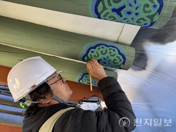 청평사 회전문 전통 단천에 동록 안료를 적용하는 모습 (제공: 춘천시청) ⓒ천지일보 2025.11.18.