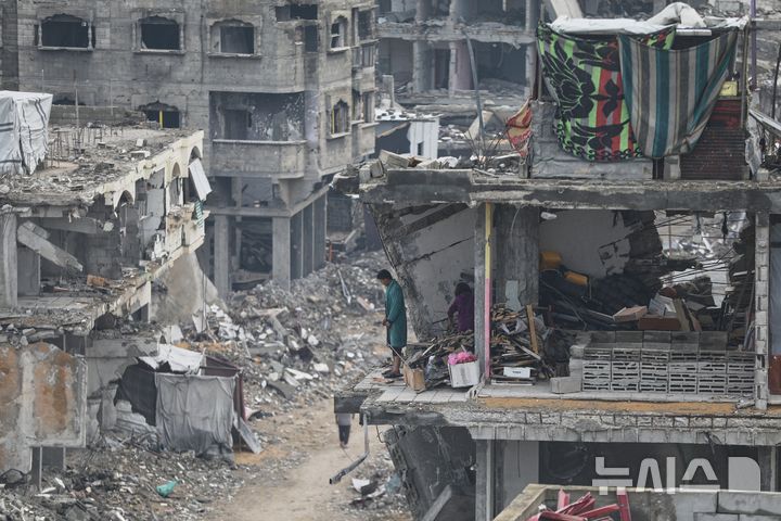 14일(현지시간) 가자지구 가자시티에서 팔레스타인 주민이 ​​이스라엘의 폭격으로 파괴된 주택의 잔해에 둘러싸인 파손된 아파트에 서 있다. (출처: 뉴시스)